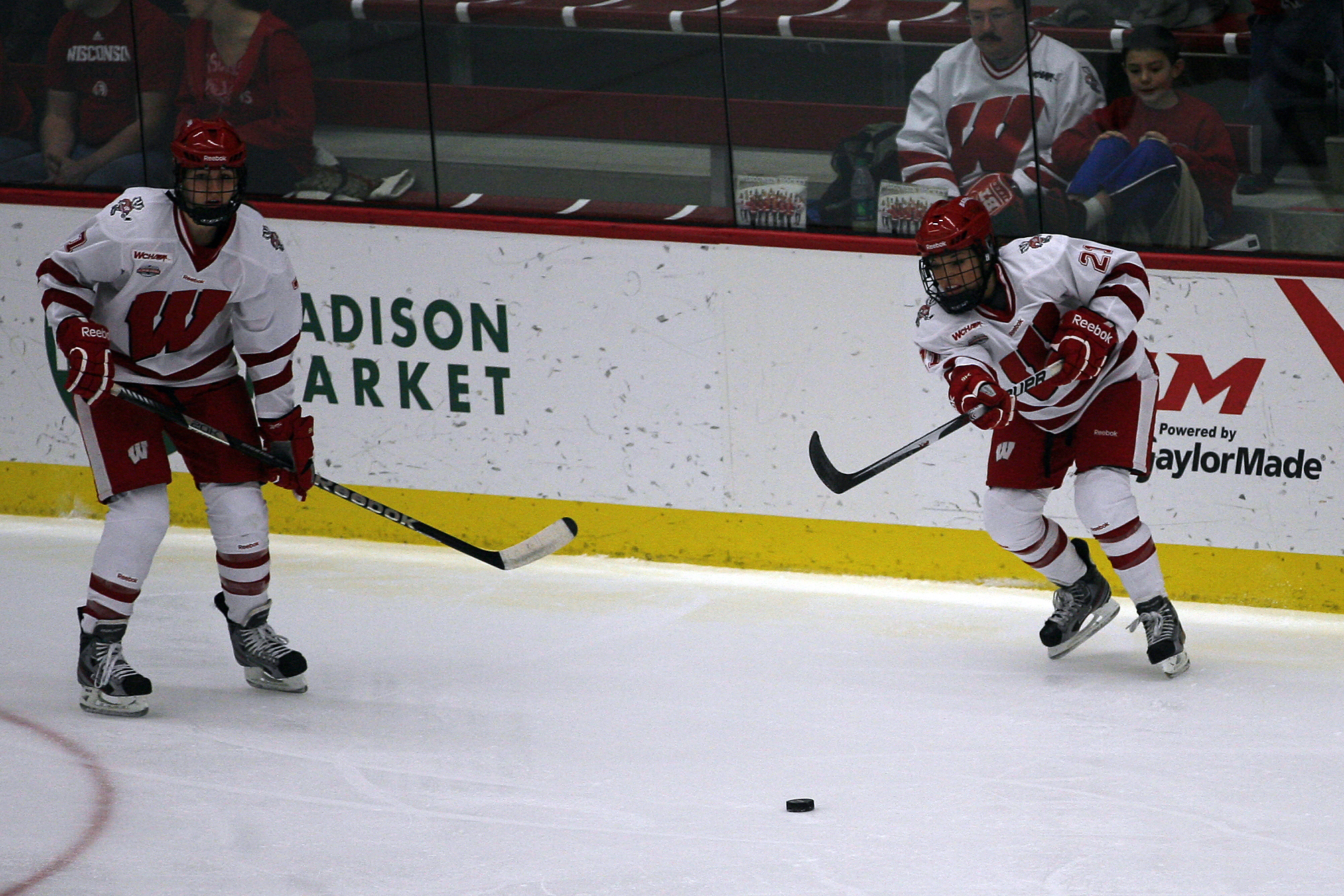 two people in uniform playing on an ice rink