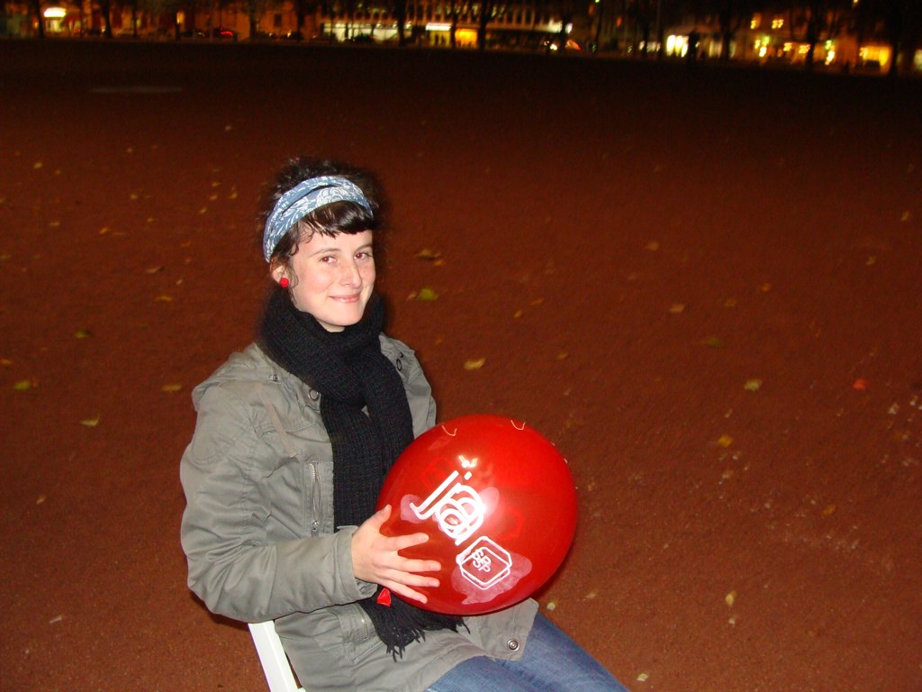 the boy is sitting in the park with his red frisbee