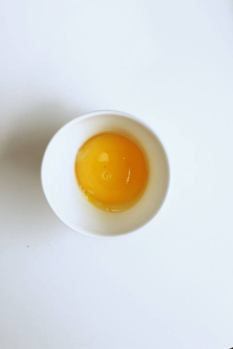 an egg yolk is in a small bowl