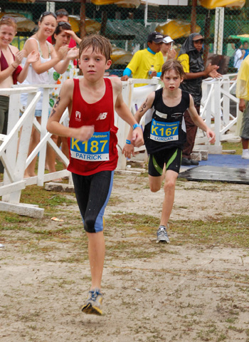 two children running side by side in shorts and shirts