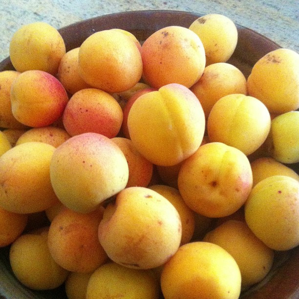 several ripe fruits sit in a bowl on the table