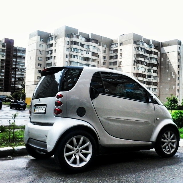 a small smart car parked next to a building