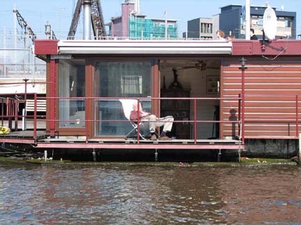 a house boat docked in the water with a deck