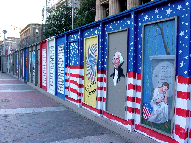 a wall with several pictures and flags painted on it
