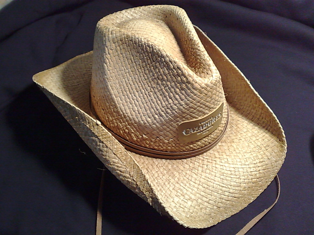 a hat laying on top of an unlined bed