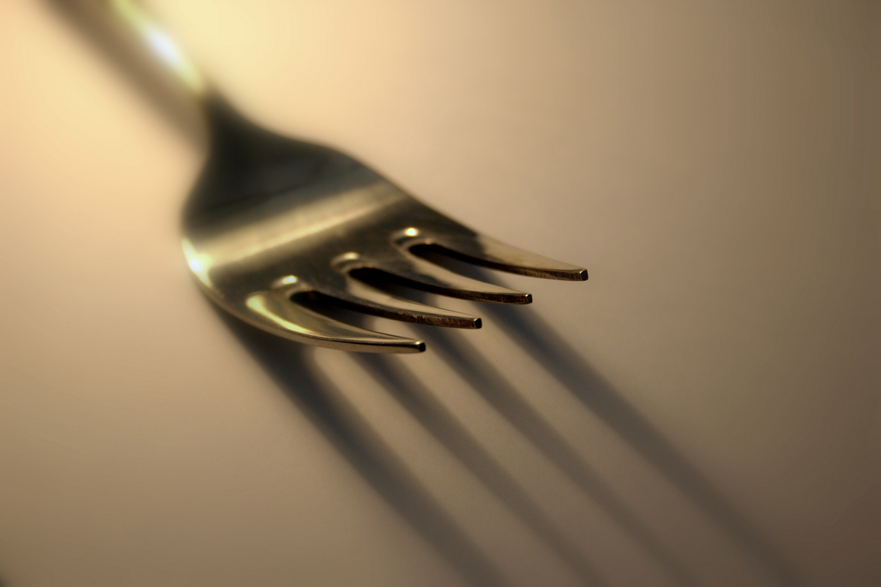 a silver fork sticking into the wall