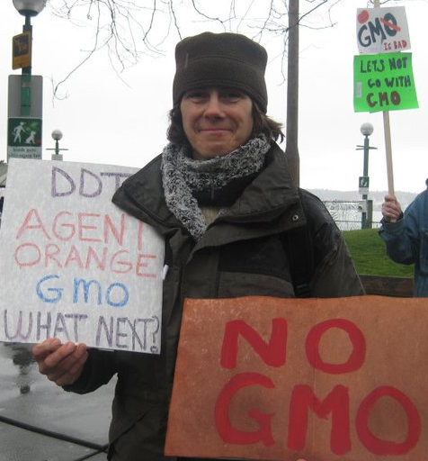 a person holding a sign reading do not agent orange gmo what new? and no gmos