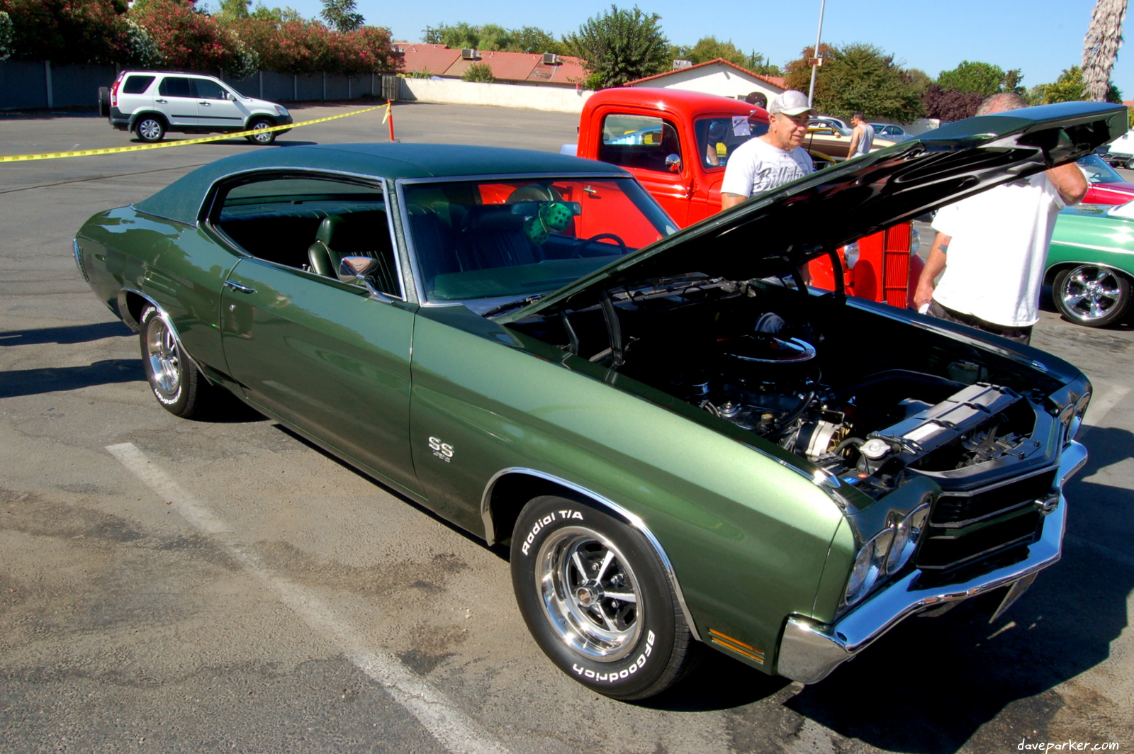 a car that is green with a hood open