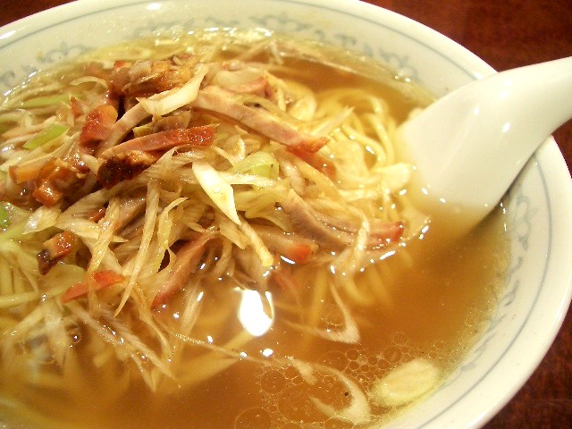 a bowl of soup with noodles in broth and vegetables