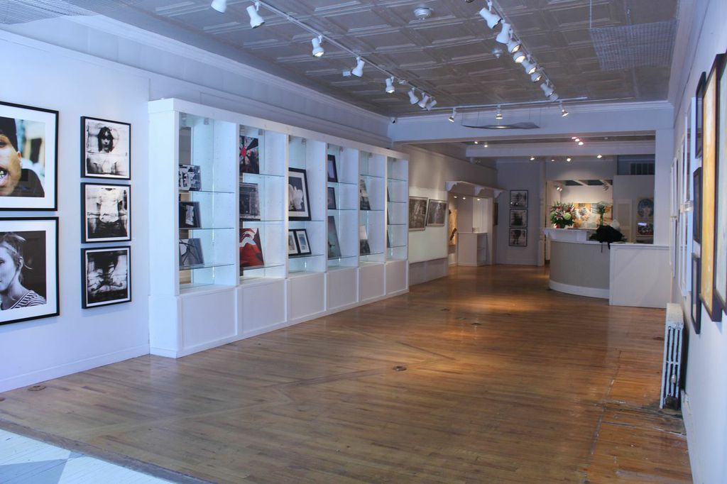 a museum hall with multiple frames and pos on the wall