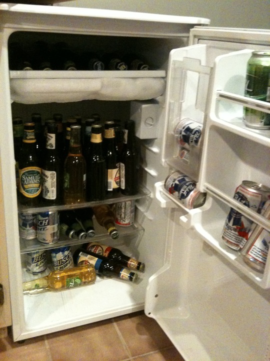 an open refrigerator with multiple bottles of beer in it