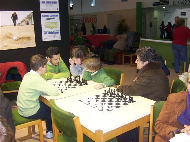 several people sitting around a white table with chess
