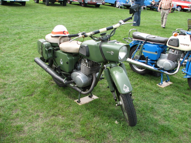 the two motorcycles are parked side by side on the grass