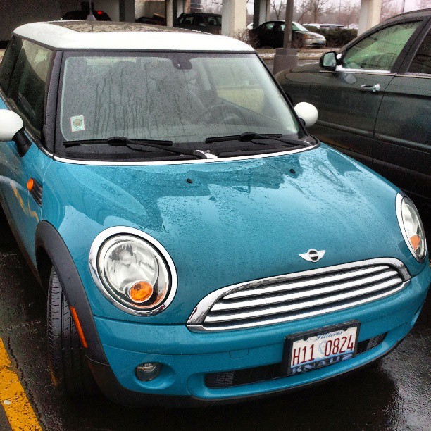 a mini in blue parked on a city street