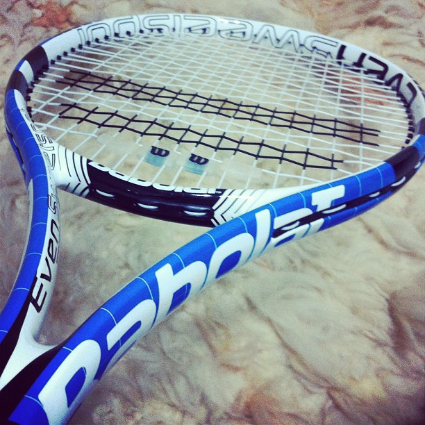 two tennis racquets sitting side by side on a rock surface