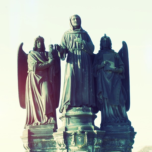a statue of an angel, two statues of a lady and a man