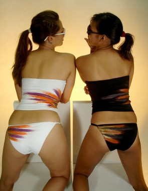 two women in swimsuits are facing back in an artistic image