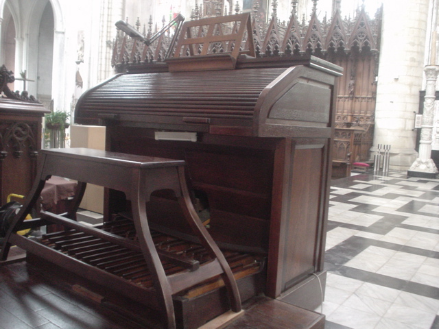 an antique upright piano in a church