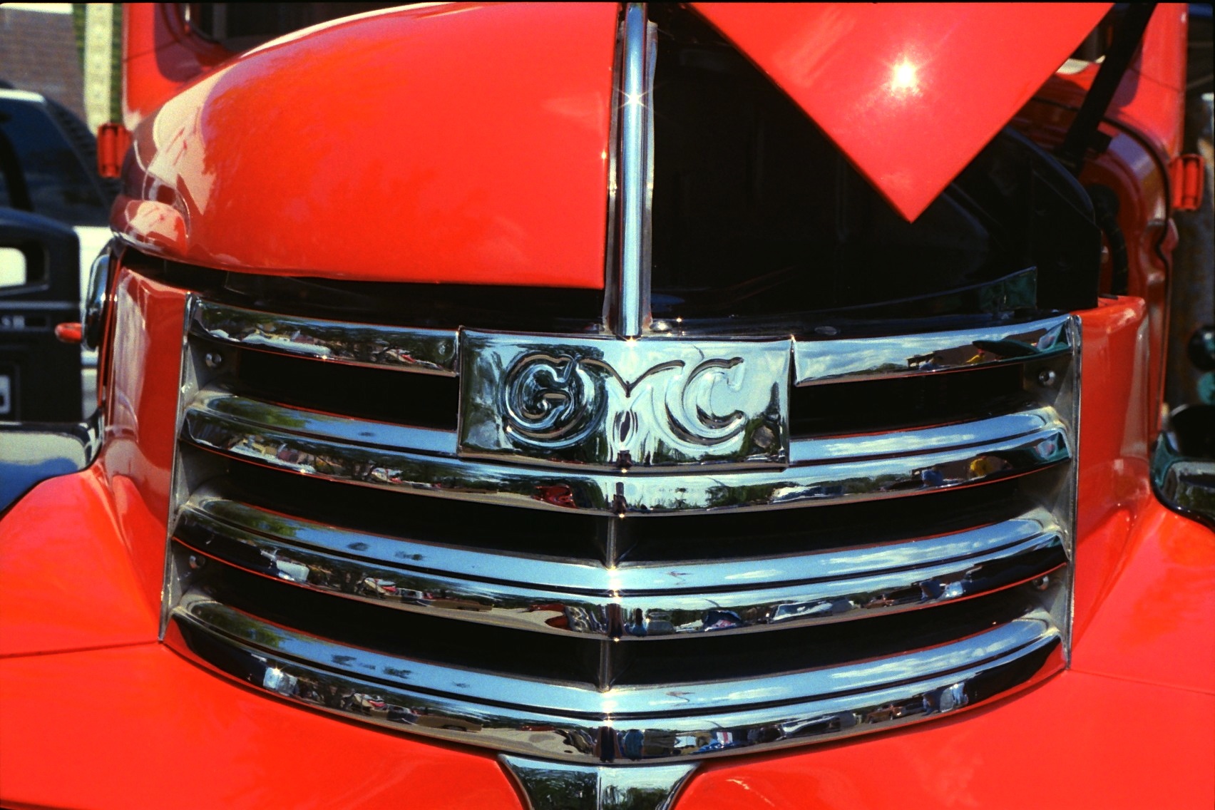a closeup of the chrome front grill and grill caps on an old model truck