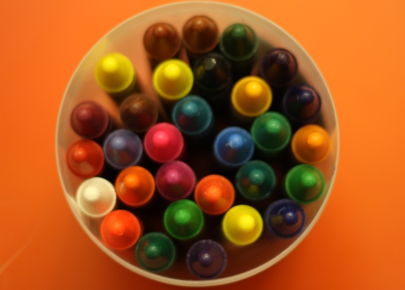 there are many colored markers in a white cup