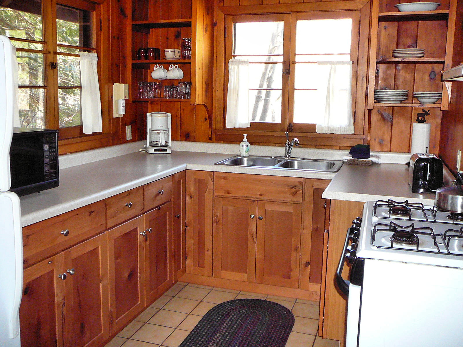 a kitchen with a stove, refrigerator and microwave