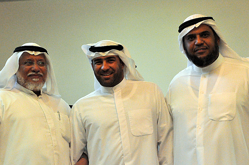 three men in traditional arabian clothing with white beards and two are smiling at the camera