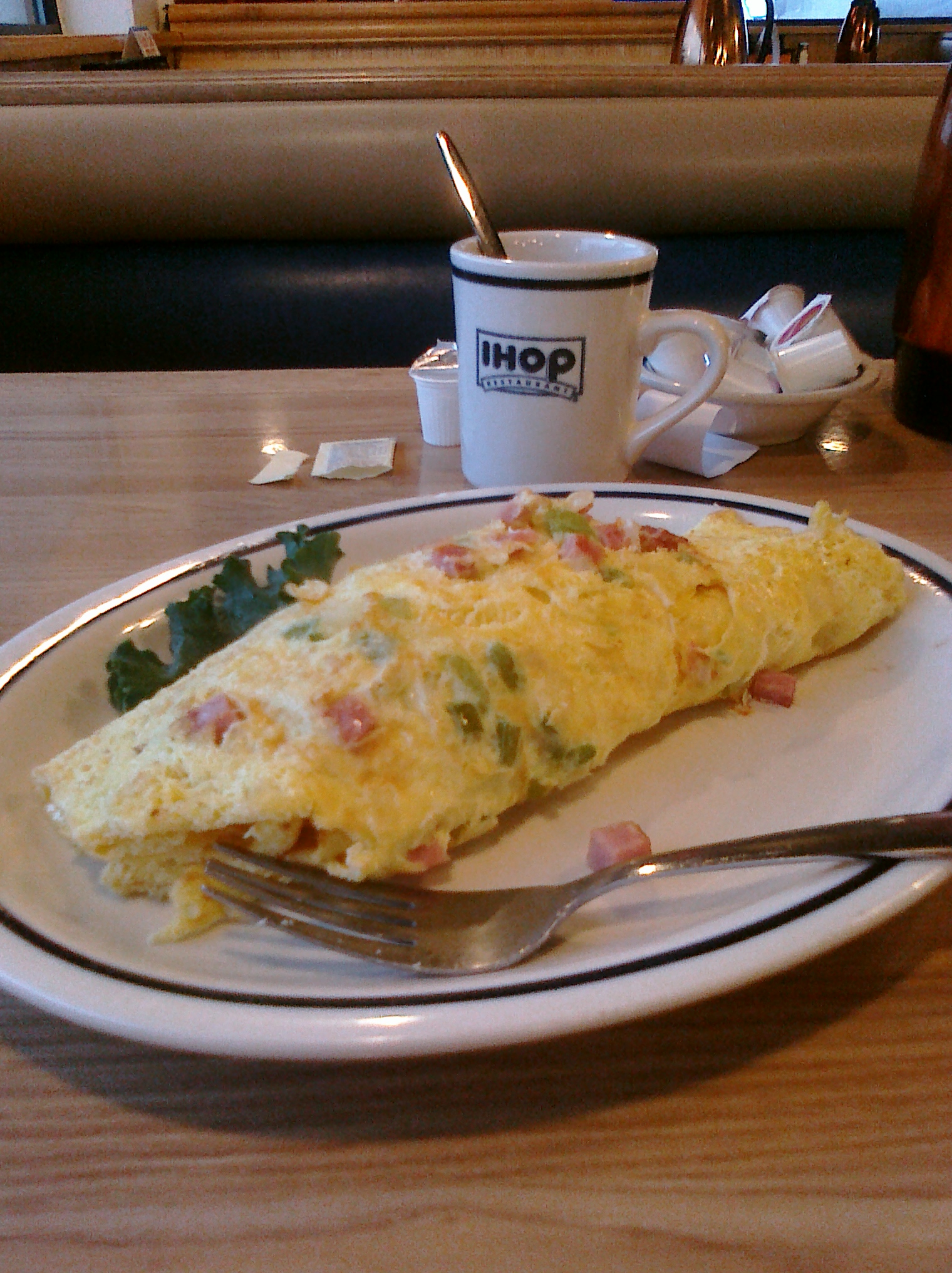 an omelet sitting on top of a white plate next to a cup