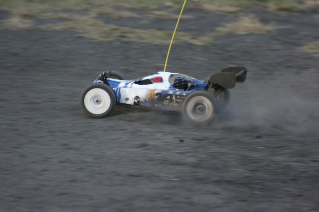 there is a car with wheels and wheels kicking up dirt