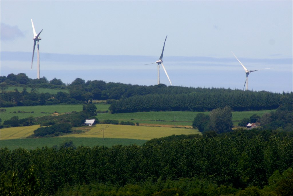 wind farm on the outskirts of a hilly green countryside