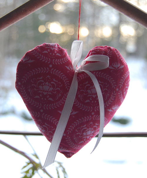 an heart shaped cushion hanging from the top of a door