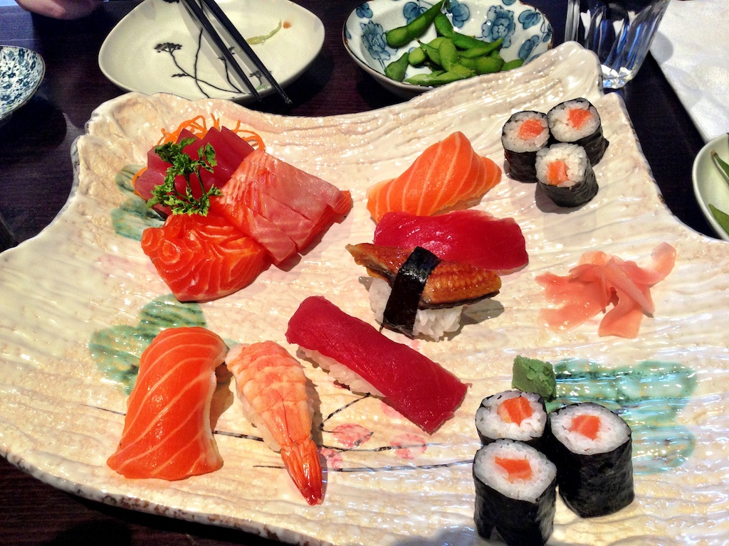 a tray is displayed displaying sushi and shrimp