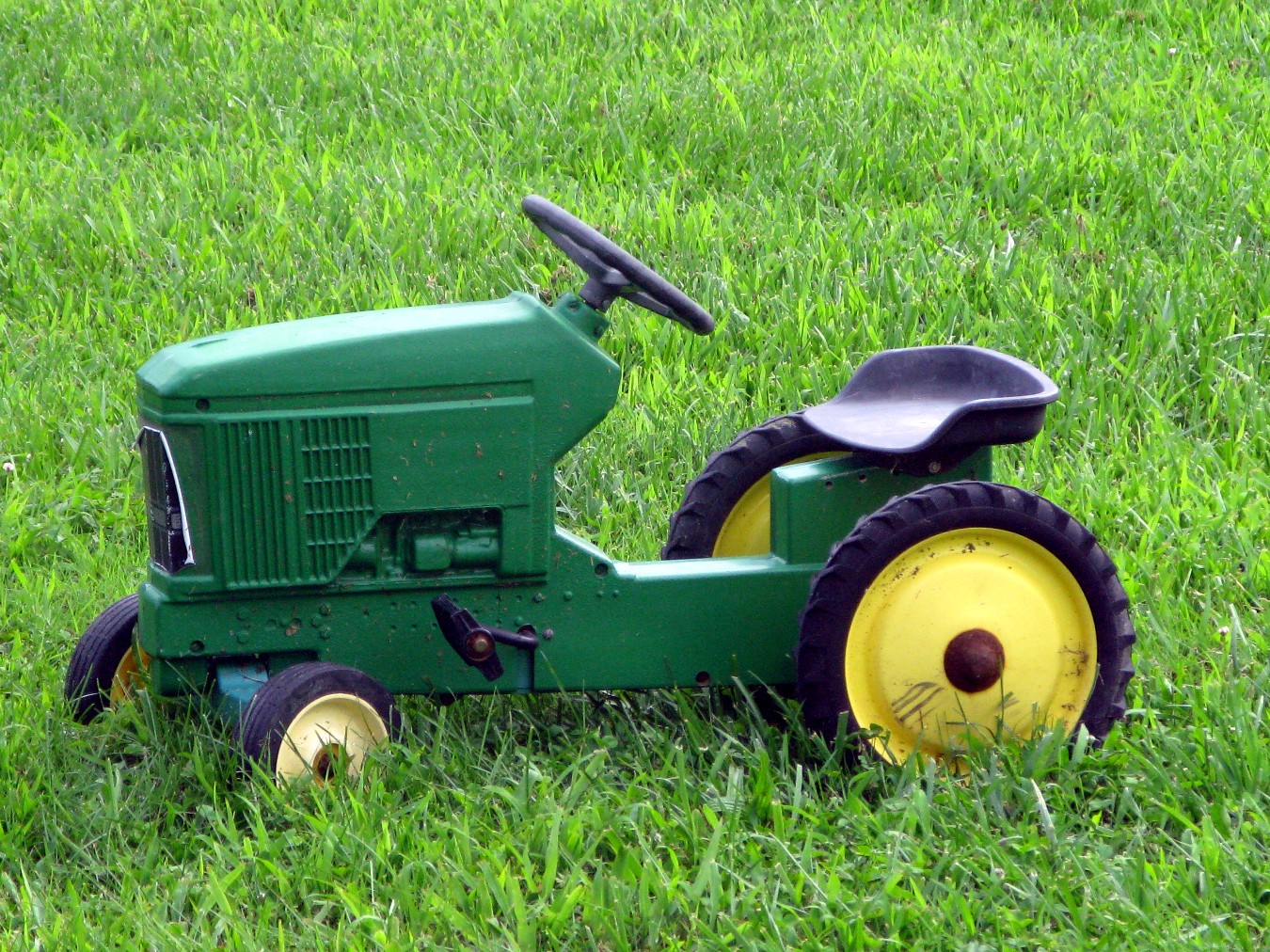 a green tractor sitting in the grass