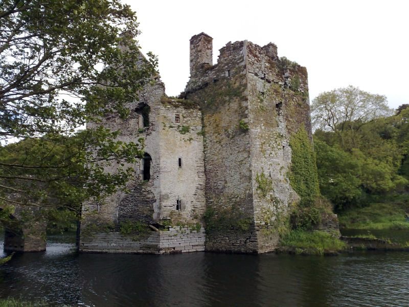 an old castle sitting on the side of a river
