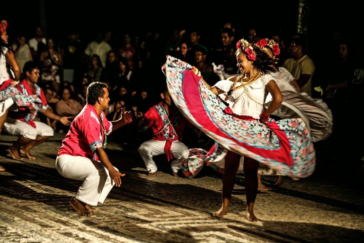 some women dancing in some outfits and holding long frisbees