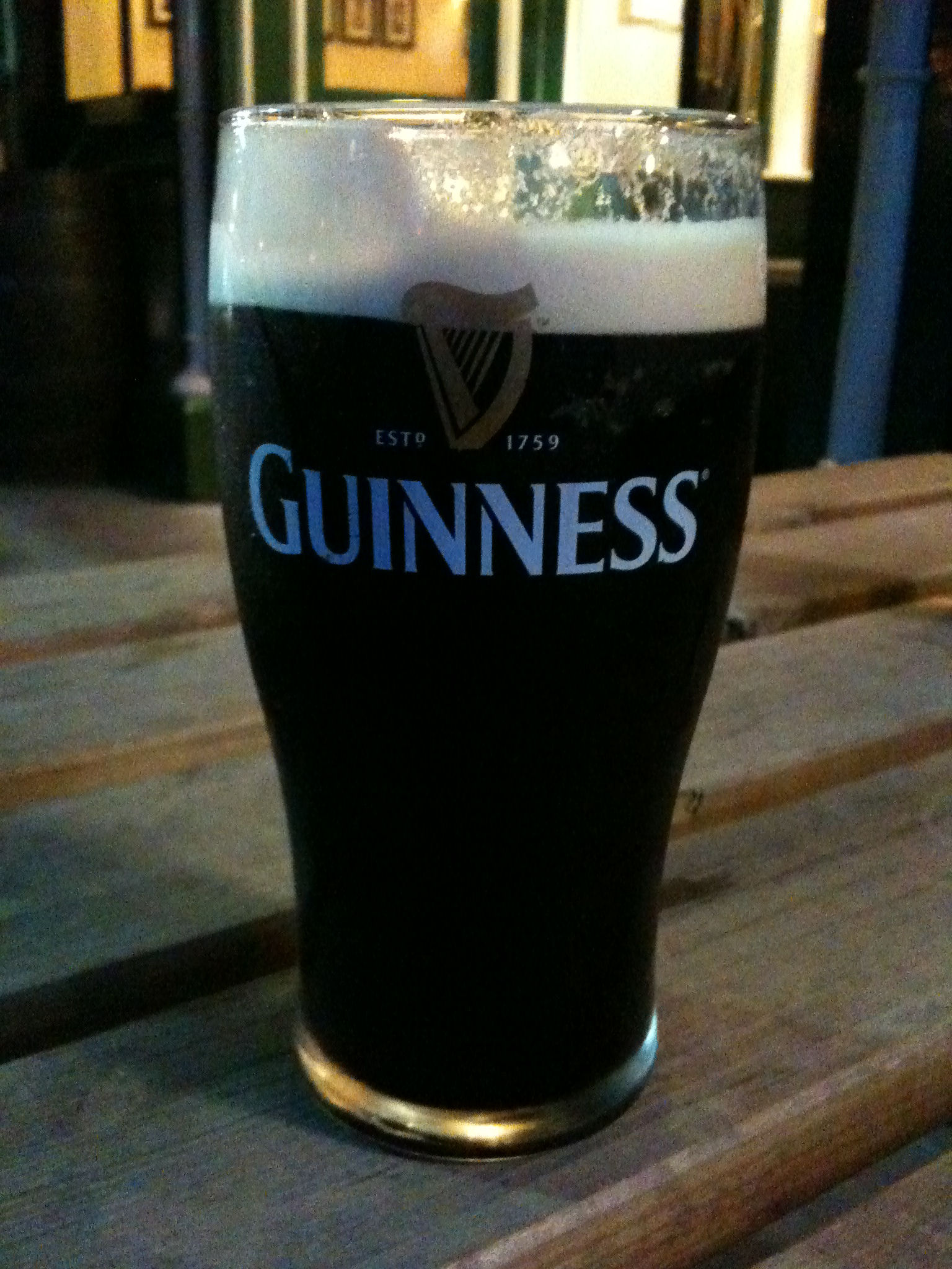 glass of beer sitting on top of a table