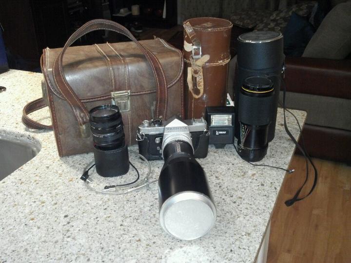 a table with a bag and several cameras