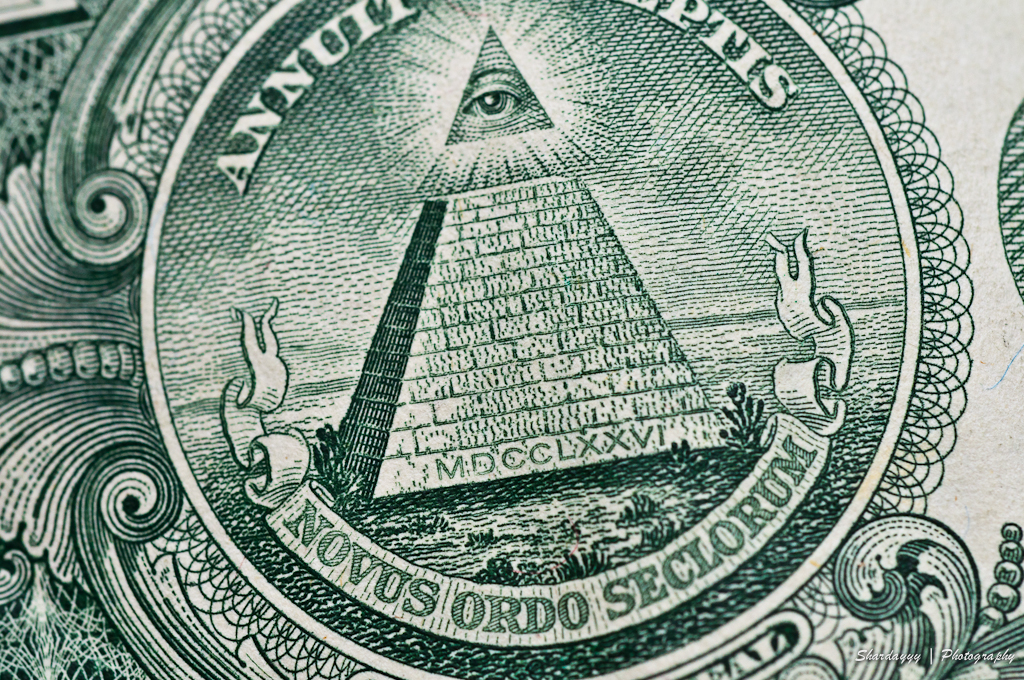an all seeing pyramid on top of a one dollar bill