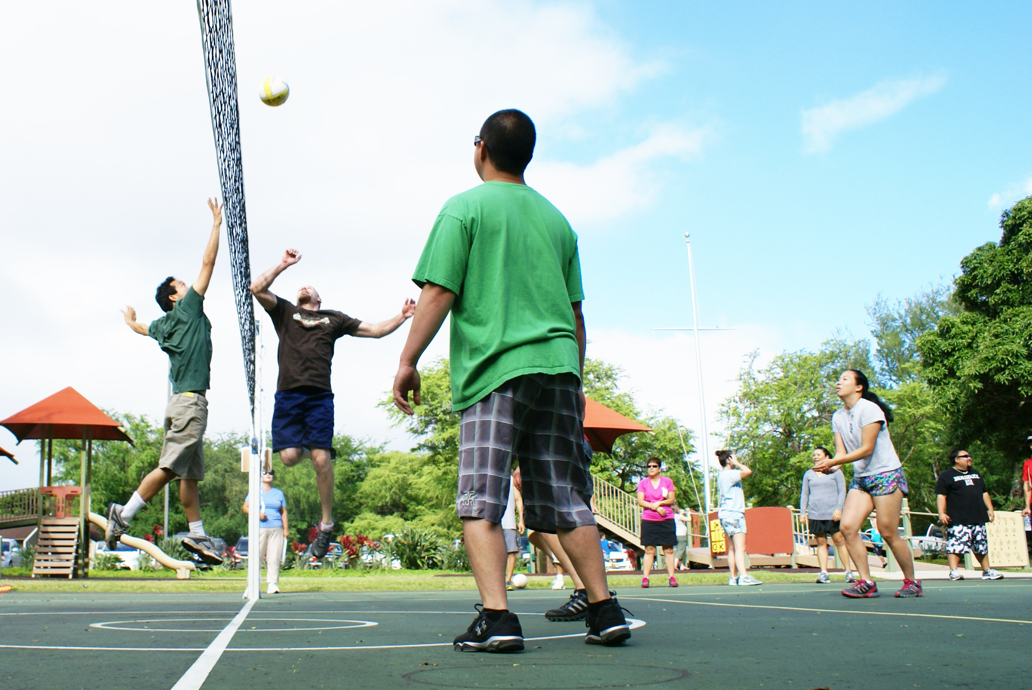 group of men playing volleyball in outdoor park