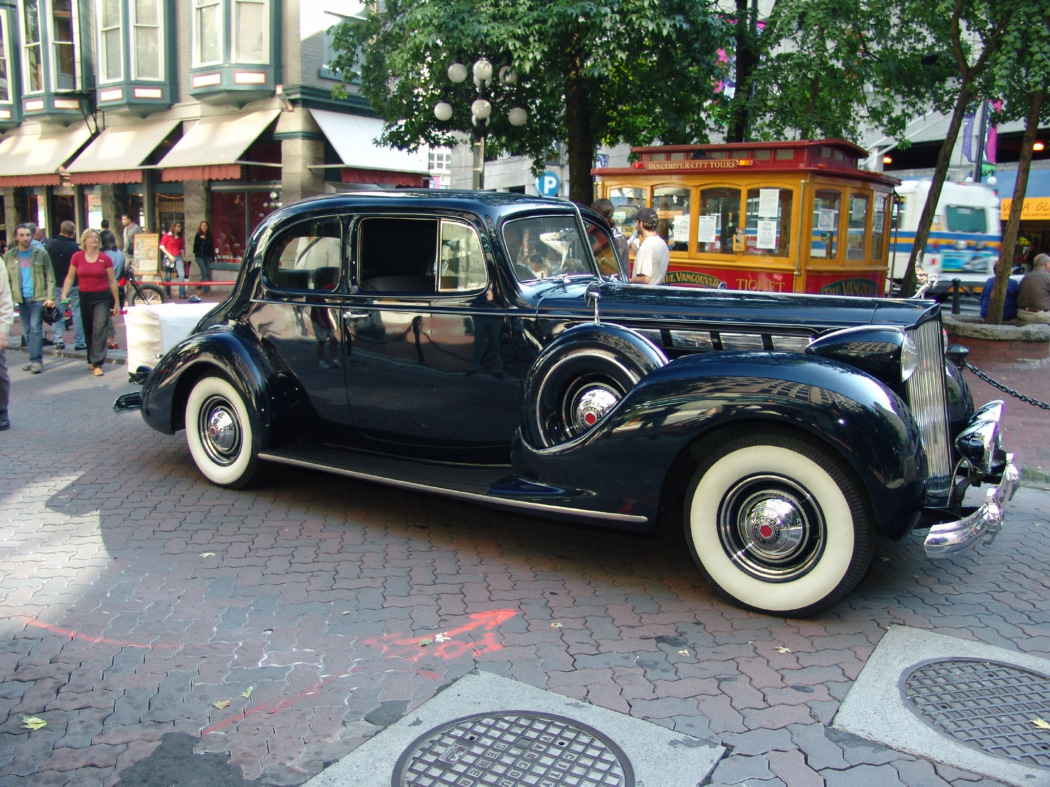 a classic black car is parked on the sidewalk