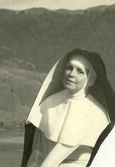 an old black and white po with an nun holding her hands up