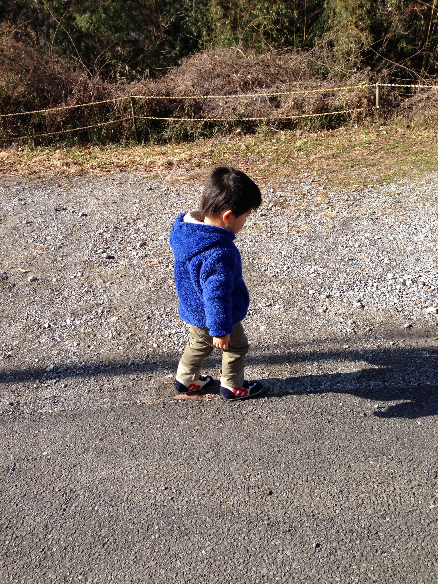 a child standing by a motorcycle with no shoes