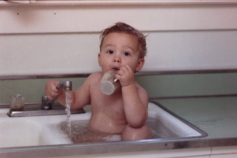a baby that is in a sink with a bottle