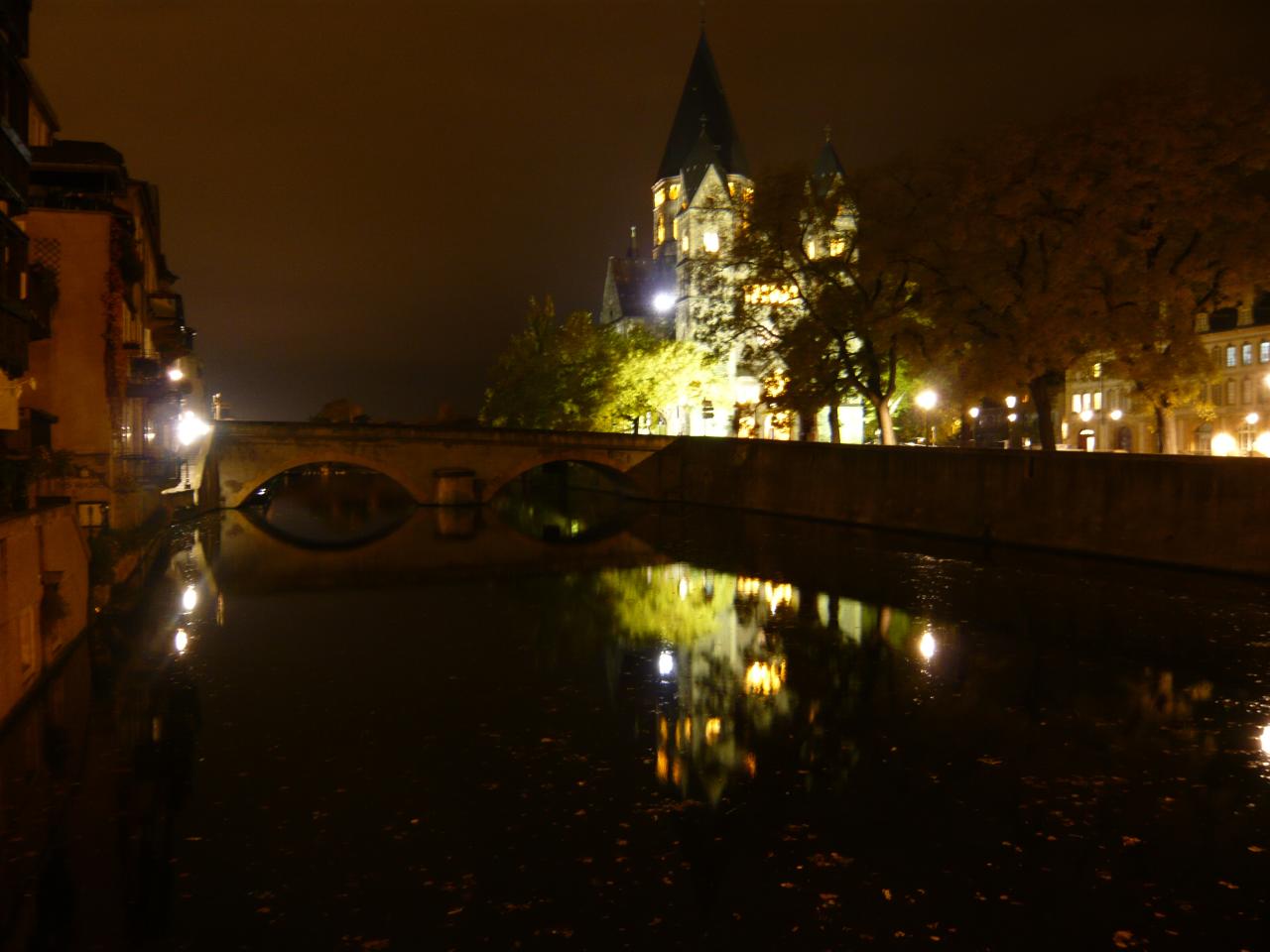 a dark canal and bridge over it at night