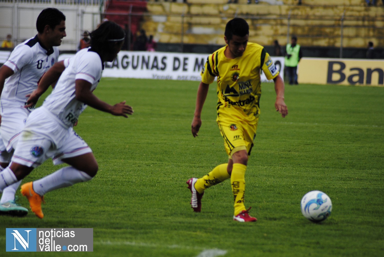 two opposing players playing soccer in the midst of an arena