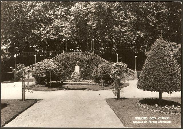 a formal garden with lots of trees, plants and benches