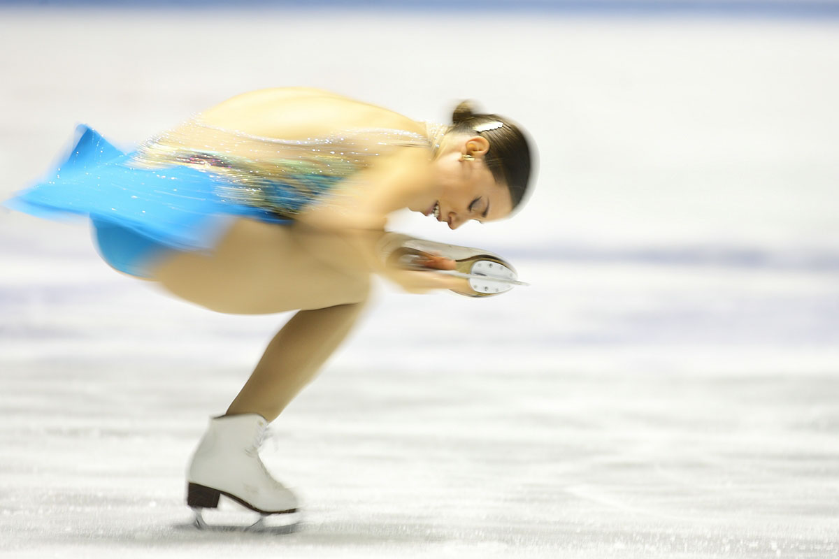 a woman in blue figure skating on ice