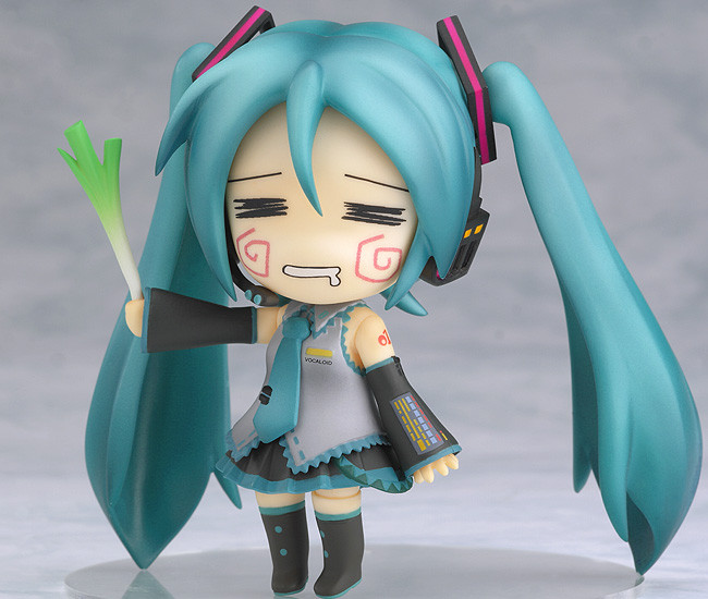 a blue haired doll with long blue hair holding a green stick