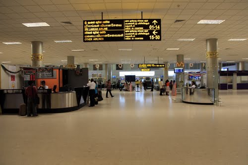 a large airport with several people waiting for their luggage