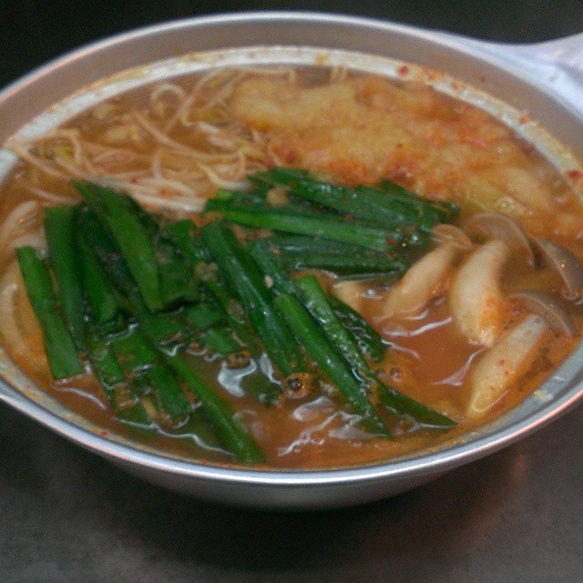 a bowl of noodle soup with green beans and sauce