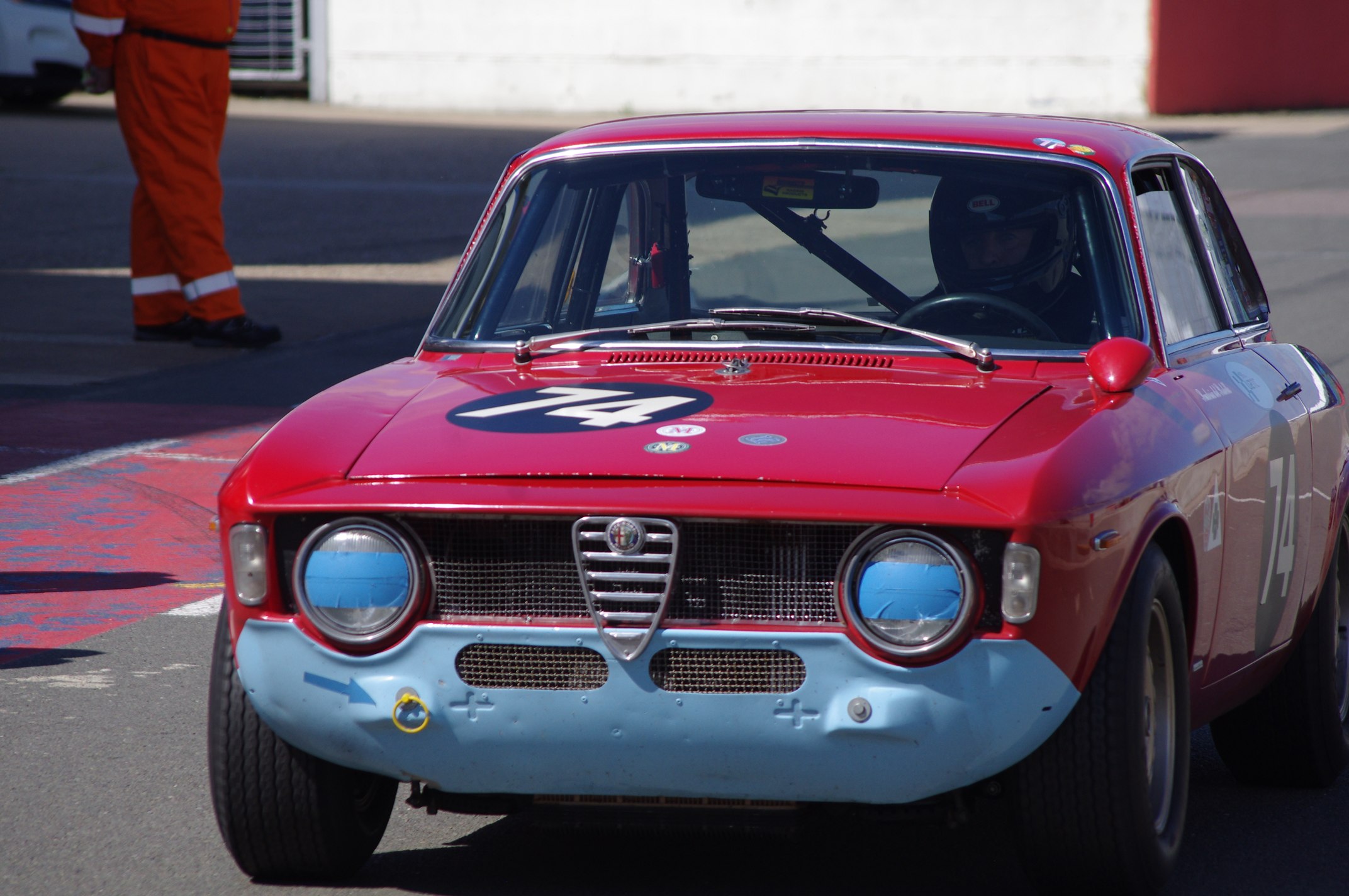 a man walks around while observing a race car